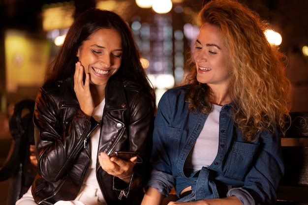 Femme montrant quelque chose à son amie au téléphone