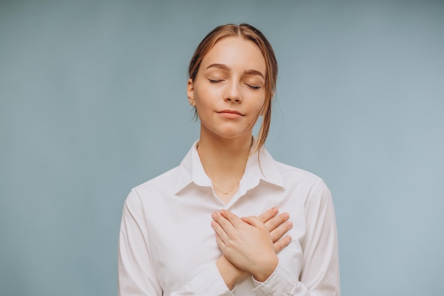 Femme montrant la sérénité avec ses mains sur la poitrine