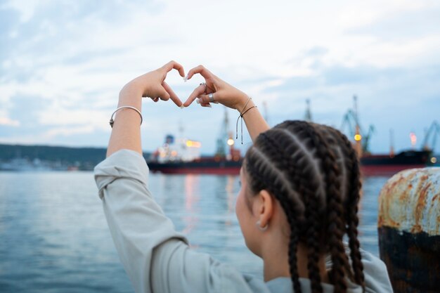 Femme montrant un signe de coeur avec les mains en guise d'amitié