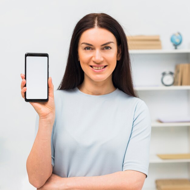 Femme montrant un smartphone avec écran blanc