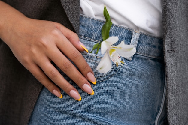 Femme montrant son nail art sur les ongles avec fleur