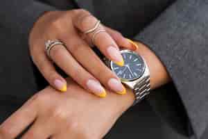 Photo gratuite femme montrant son nail art sur les ongles avec montre
