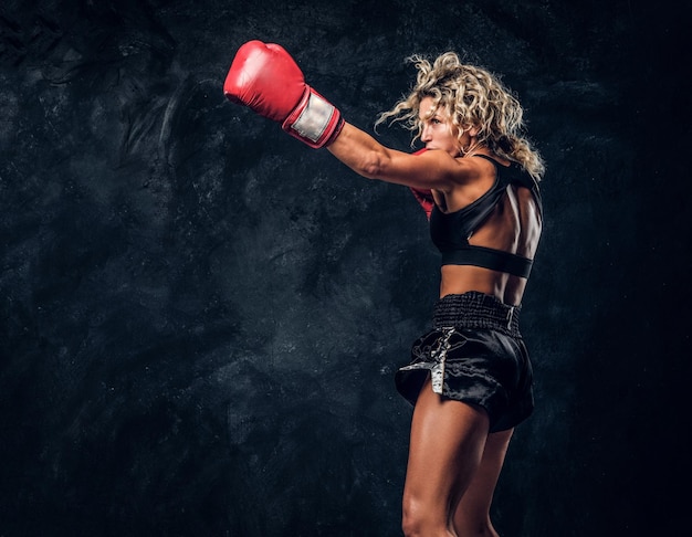 Photo gratuite une femme musclée sportive fait la démonstration de ses exercices de boxe, portant des gants.