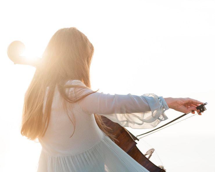 Photo gratuit femme musicienne jouant du violoncelle au soleil