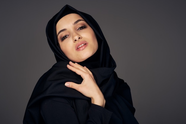 Femme musulmane en noir hijab religion fond sombre