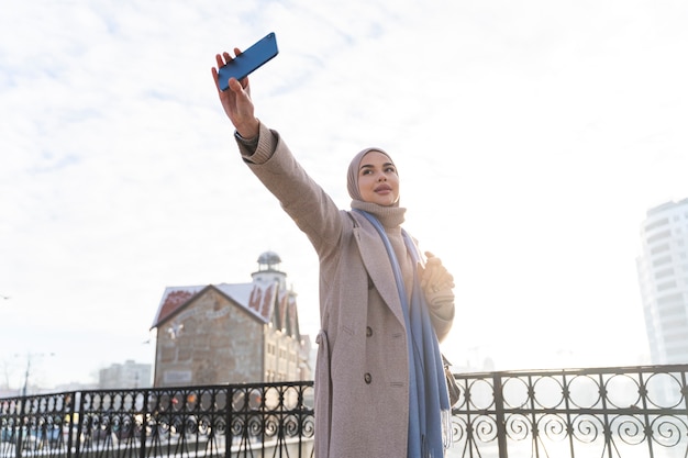 Femme musulmane prenant un selfie lors d'un voyage