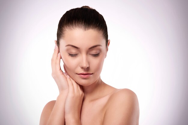 Femme naturelle avec les mains à côté du visage