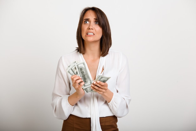 Une femme nerveuse compte que l'argent doit payer sa dette