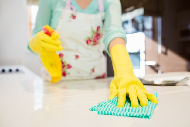 Femme nettoyant cuisine worktop