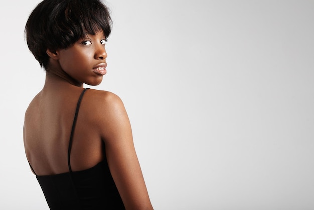 Une femme noire avec une coupe de cheveux courte porte des bretelles