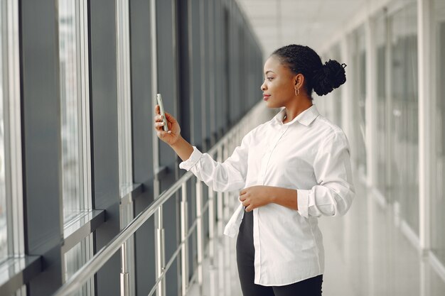 Femme noire, debout, dans, bureau, à, a, ordinateur portable