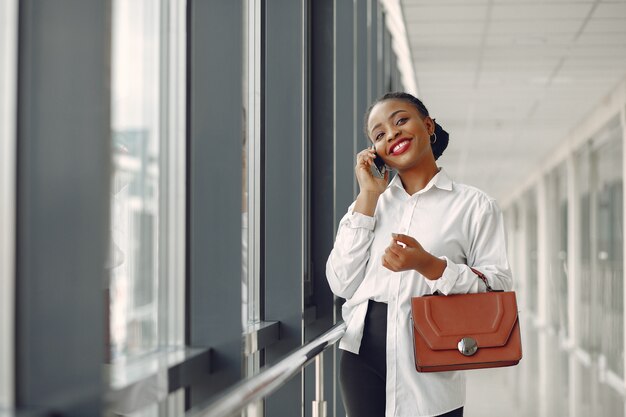 Femme noire, debout, dans, bureau, à, a, ordinateur portable