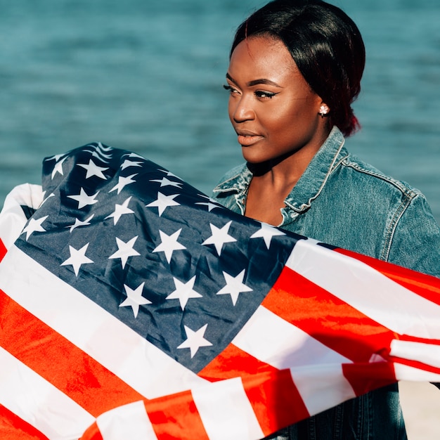 Photo gratuite femme noire debout et tenant le drapeau américain