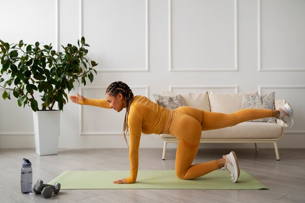 Femme noire faisant du fitness à la maison