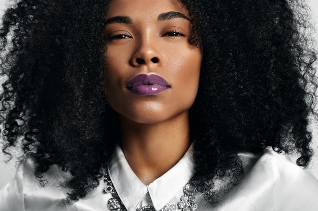 Femme noire avec des lèvres brillantes violettes à la mode