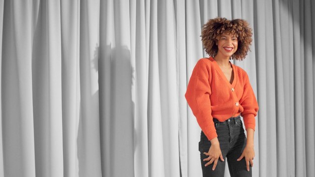 Femme noire métisse aux cheveux bouclés et au maquillage chaud naturel pour la peau foncée Danser et rire