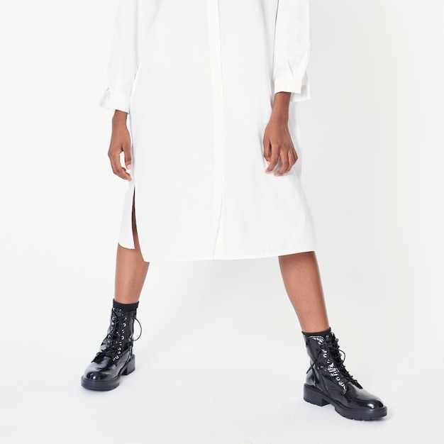 Femme noire portant des bottines avec une robe chemise blanche