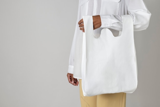Photo gratuite femme noire portant un sac d'épicerie réutilisable blanc