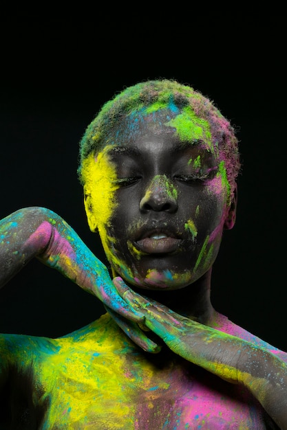 Femme noire posant avec de la poudre colorée