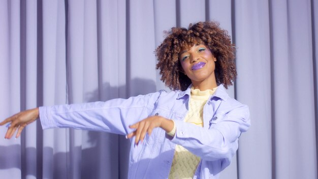 Femme noire de race mixte avec portrait de cheveux bouclés dans des tons de printemps pastel dansant