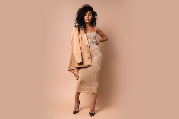 Photo gratuit femme noire sensuelle avec de beaux cheveux ondulés en robe brillante dorée posant. toute la longueur.