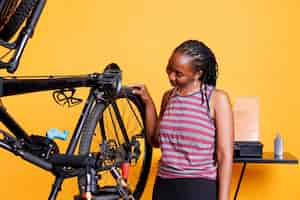 Photo gratuite une femme noire vérifie un pneu de vélo.