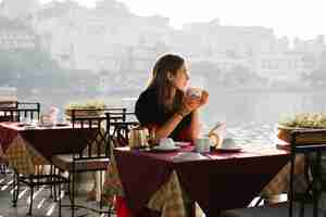 Photo gratuite femme occidentale ayant un thé dans un café à udaipur