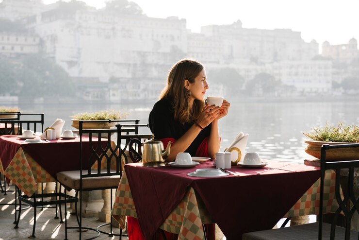 Photo gratuit femme occidentale ayant un thé dans un café à udaipur