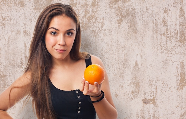 Photo gratuite femme avec une orange dans sa main