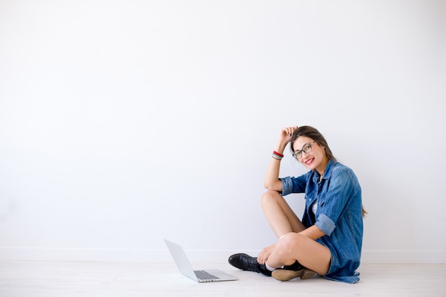 femme avec ordinateur portable assis avec les jambes croisées