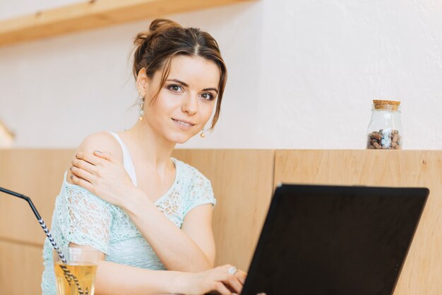 Femme avec ordinateur portable au café