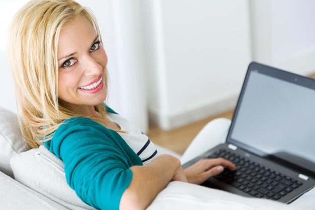 Femme avec un ordinateur portable regardant la caméra