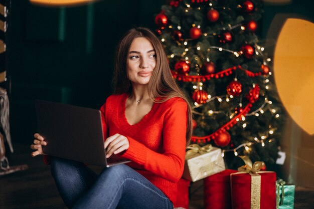 Femme avec ordinateur portable avec sapin de Noël