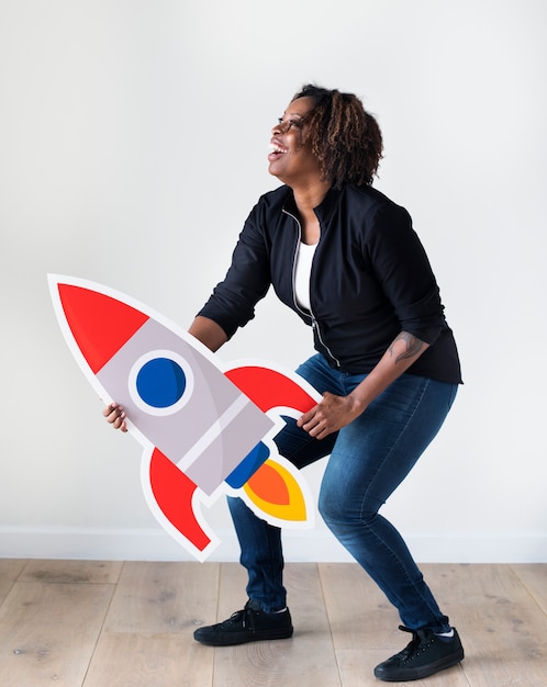 Photo gratuite femme d'origine africaine tenant l'icône de fusée