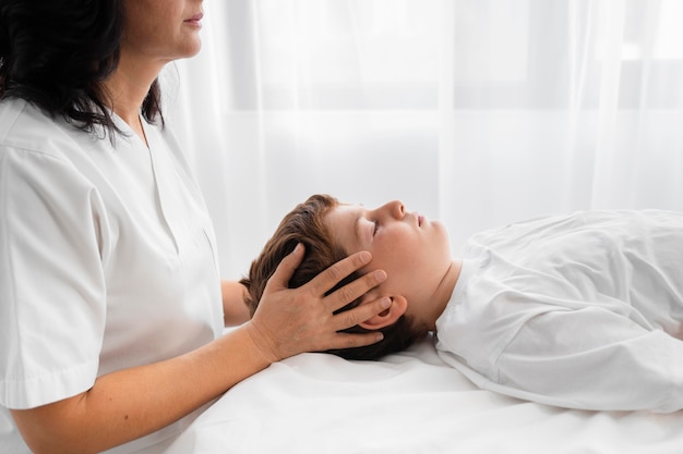 Femme ostéopathe traitant un enfant à l'hôpital