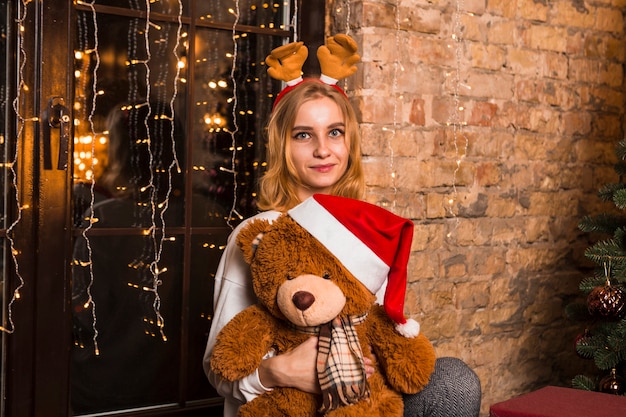 Femme avec un ours en peluche à Noël