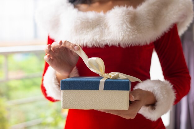 Femme ouvrant des cadeaux de Noël