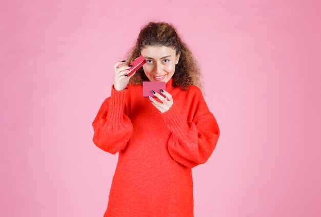 femme ouvrant une petite boîte-cadeau et est surprise.