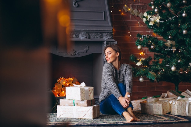 Femme, par, arbre noël, déballage, présente