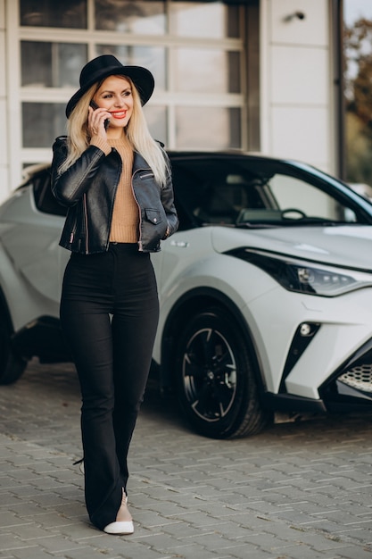 Femme parlant au téléphone par sa voiture