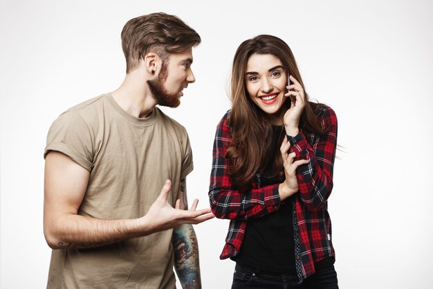 Femme parlant au téléphone souriant joyeusement à côté d'un ami