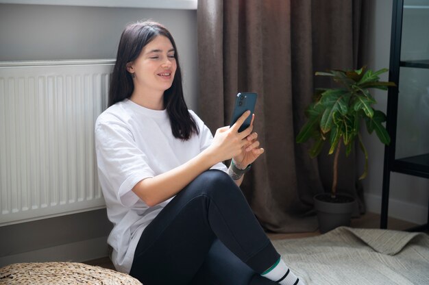 Femme parlant sur son smartphone à la maison pendant la quarantaine