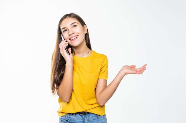 Femme parlant sur son téléphone portable sur un mur blanc