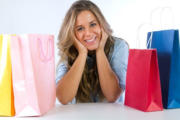 Femme parmi les sacs sourire heureux