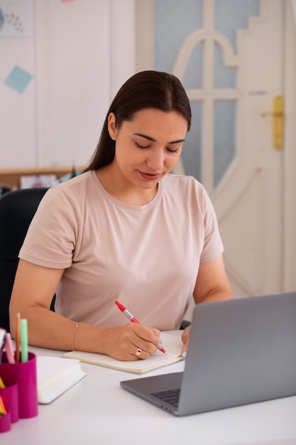 Photo gratuite femme passant un appel vidéo à l'aide d'un ordinateur portable depuis son domicile