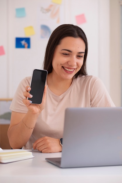 Photo gratuite femme passant un appel vidéo à l'aide d'un ordinateur portable depuis son domicile