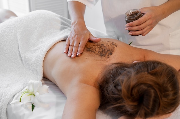 Femme passant du temps au spa et recevant un massage exfoliant