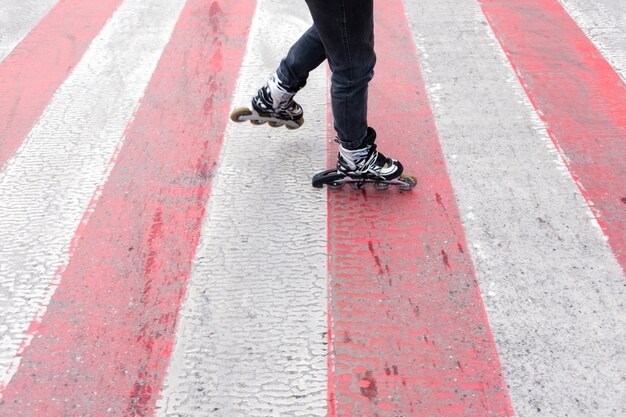 Femme en patins à roues alignées sur le passage pour piétons