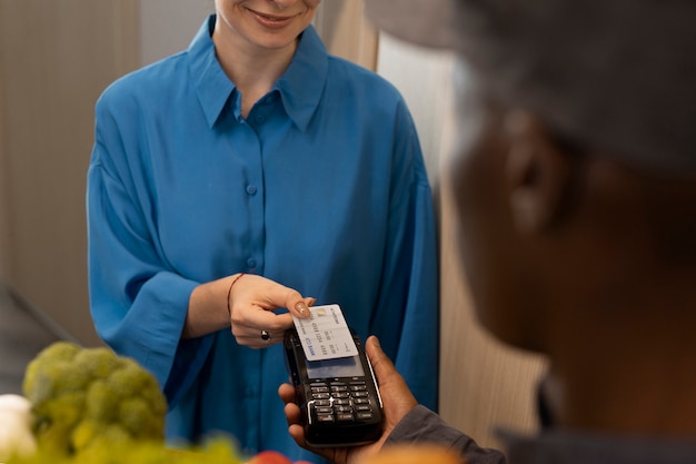 Photo gratuite femme payant l'épicerie vue de face