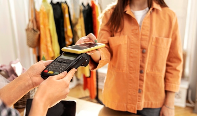 Femme payant des vêtements au magasin